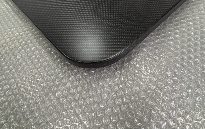 Texto alternativo: Primer plano de un panel sándwich de fibra de carbono con un borde del núcleo inacabado y expuesto.